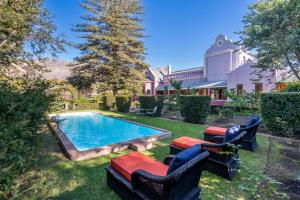 a yard with a swimming pool with chairs and a house at La Rochelle in Montagu