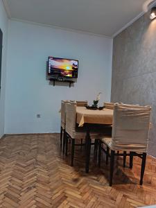 a dining room with a table and chairs with a television on the wall at Apartment Olimp Ulcinj in Ulcinj