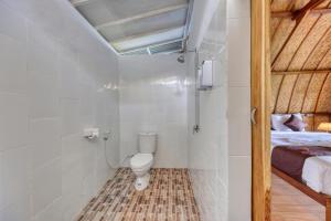 a bathroom with a toilet and a bed in a room at The Penida Angmas View in Nusa Penida +35 photos