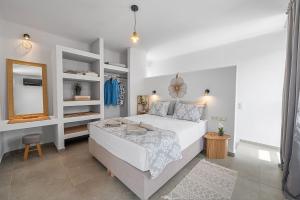 a bedroom with a large white bed and a mirror at The Aer Element Of Gaea in Loutrá