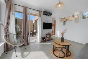a living room with a table and chairs and a tv at The Aer Element Of Gaea in Loutrá