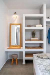 a bedroom with a mirror and a stool and a bed at The Aer Element Of Gaea in Loutrá