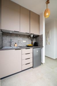 a kitchen with white cabinets and a counter top at The Aer Element Of Gaea in Loutrá +39 photos