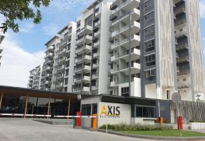 a large white apartment building with akas sign in front of it at Axis Residences By The Team in Phnom Penh