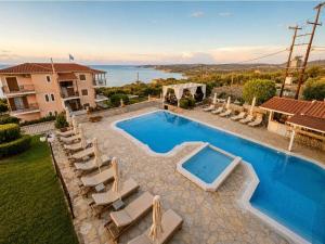 a villa with a swimming pool and lounge chairs at Aristomenis Studios in Vlachata