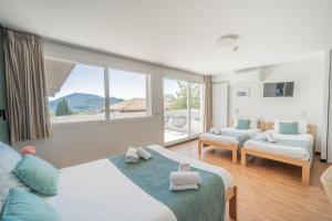 a living room with two beds and a large window at Centre Jean XXIII in Annecy +176 photos