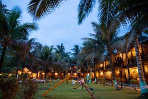 a resort with a playground with a slide and palm trees at TSG Aura in Neil Island