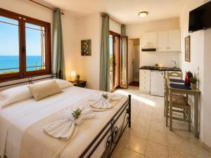 ein Schlafzimmer mit einem großen Bett und Meerblick in der Unterkunft Aristomenis Studios in Vlachata + 108 Fotos