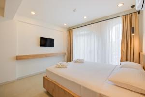 a bedroom with a large white bed and a window at Miralya Downtown in Fethiye +11 photos