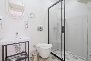 a white bathroom with a toilet and a shower at Miralya Downtown in Fethiye
