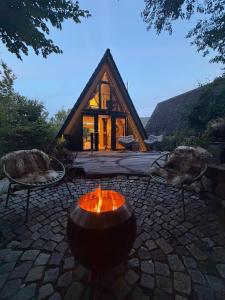 a fire pit in front of a log cabin at Alva Rhön Panorama Ferienhaus - Auszeit mit Kamin in Frankenheim