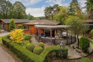 a wooden house with a fence in a yard at Bungalowpark Het Verscholen Dorp in Harderwijk