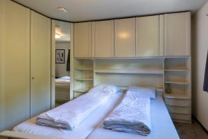 a small bedroom with a bed with white sheets at Bungalowpark Het Verscholen Dorp in Harderwijk +48 photos