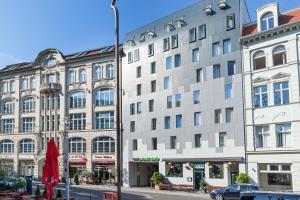 a large white building on a city street at Hotel Gat Point Charlie in Berlin
