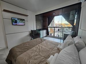 a bedroom with a large bed and a large window at Studio moderno no centro próximo a Academia e Cave in Juiz de Fora +3 photos