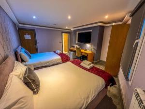 a hotel room with two beds and a television at Fountain House in Boston