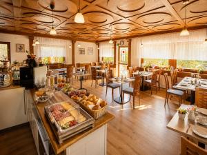 a restaurant with a buffet with tables and chairs at Haus Rose in Allensbach
