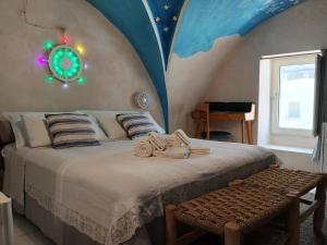 a bedroom with a bed with a clock on the wall at B&B "Pulia Dimore Salentine" in Alessano +115 photos