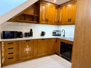a kitchen with wooden cabinets and a sink at Gorczański Wierch in Maniowy