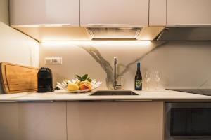 a kitchen counter with a sink and a bottle of wine at Miramare Apartments&Suites in La Spezia