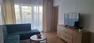 a living room with a blue couch and a tv at Apartament Sobieskiego 2, bezpłatny parking in Świebodzin