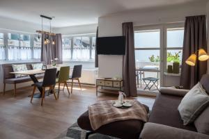 a living room with a couch and a dining room at Akzent Hotel Löwen in Langenargen