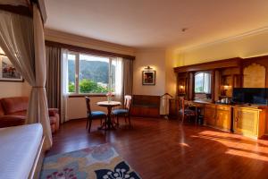 a room with a bed and a desk with a table at KK Royal Hotel & Convention Centre in Jaipur