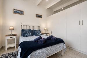 a bedroom with a bed with blue pillows on it at Jacobsdaller #1 in Jacobs Bay