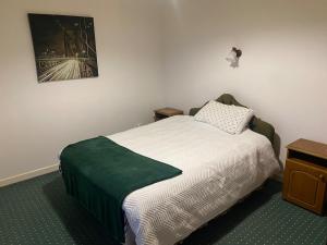 a bedroom with a bed and a picture on the wall at Farrihy Hill House in Doonbeg