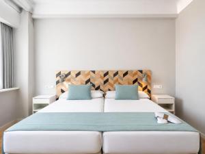 ein Schlafzimmer mit einem großen Bett und blauen Kissen in der Unterkunft Hotel Chamartin The One in Madrid + 89 Fotos