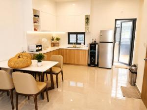 a kitchen with a table and chairs and a refrigerator at VSIP Executive Living in Hòa Lợi (1)