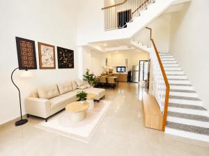 a living room with a couch and a staircase at VSIP Executive Living in Hòa Lợi (1)