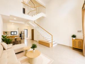 a living room with a staircase and a couch and a table at VSIP Executive Living in Hòa Lợi (1)