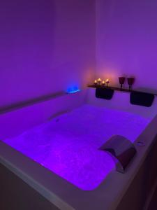a purple room with a tub filled with purple lights at AmarVite con spa privata in Dolceacqua