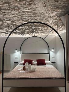 a bedroom with a bed with an iron frame at AmarVite con spa privata in Dolceacqua