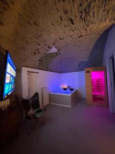 a room with a tv and a tub with purple lights at AmarVite con spa privata in Dolceacqua