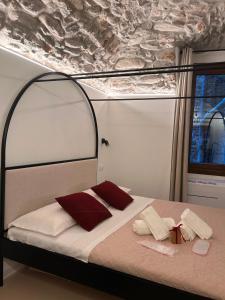a bed with red and white pillows on it at AmarVite con spa privata in Dolceacqua