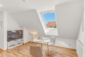 a white room with a table and chairs and a tv at Scharnhäusle 6 - wunderschönes Apartment mit Balkon in Ostfildern