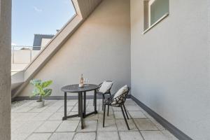 a patio with a table and two chairs on a balcony at Scharnhäusle 6 - wunderschönes Apartment mit Balkon in Ostfildern