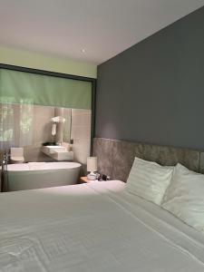 a bedroom with a bed and a bathroom with a sink at Flamingos Cat Ba pre núi in Cat Ba