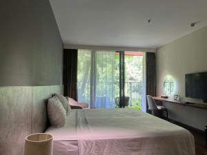 a bedroom with a bed and a desk and a window at Flamingos Cat Ba pre núi in Cat Ba