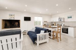 a living room with a blue couch and a kitchen at Jacobsdaller #2 in Jacobs Bay +19 photos