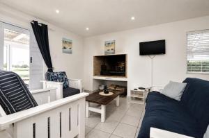 a living room with a couch and a tv at Jacobsdaller #2 in Jacobs Bay