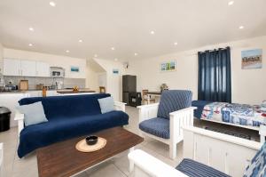 a living room with a blue couch and a table at Jacobsdaller #2 in Jacobs Bay