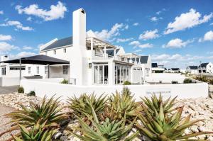 a white house with plants in front of it at Jacobsdaller #2 in Jacobs Bay