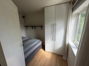 a small bedroom with a bed and a window at Charming sea view in Bergen