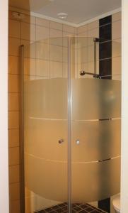 a shower with a glass door in a bathroom at Heimat Brokelandsheia in Gjerstad