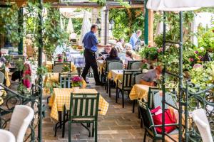 a group of people sitting at tables in a restaurant at Hotel Restaurant - Häuserl im Wald Graz in Graz