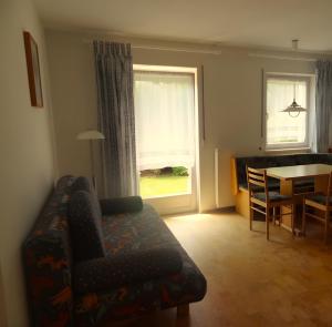 a living room with a couch and a table and a window at Renates Ferienwohnungen in Meltina