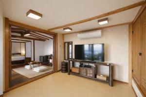 a living room with a flat screen tv on a wall at The Seaes Hotel & Resort in Seogwipo +82 photos